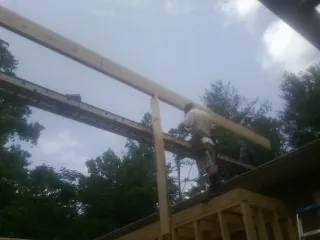 Carpenter setting a ridge beam over a new addition frame — Ice Dam Removal by Roofing Brothers in Wallsburg