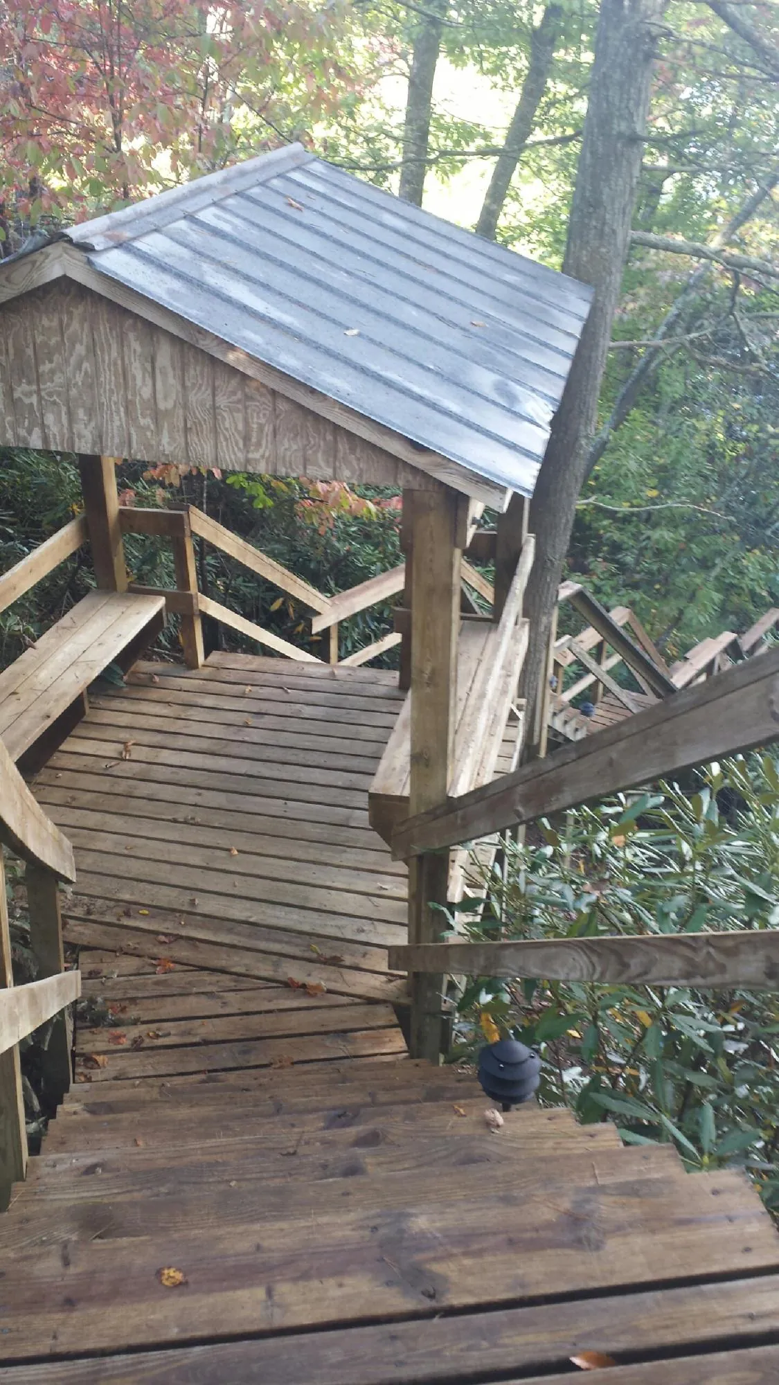 Metal roofed shelter over wooden steps on a wooded walkway — Skylight Repair & Installation work by our crew in Wallsburg